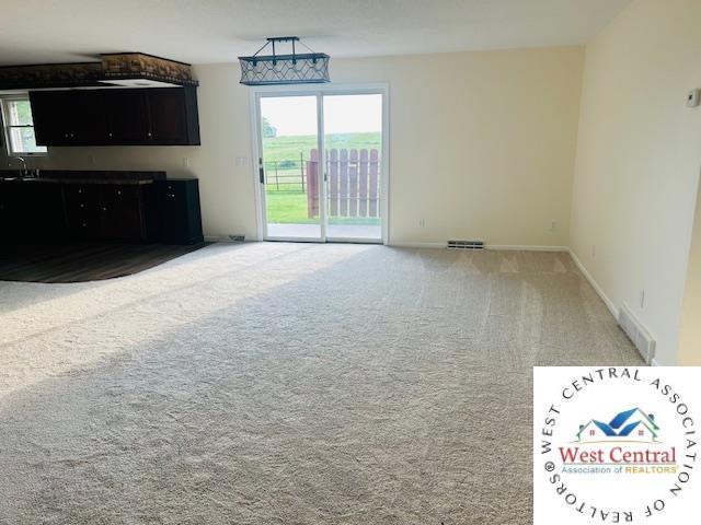 45869 E Hwy, Milan, MO 63556 - unfurnished living room with light colored carpet and a sink