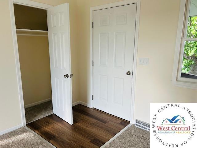 45869 E Hwy, Milan, MO 63556 - unfurnished bedroom with baseboards and dark wood-style floors