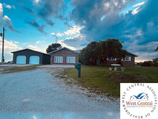 45869 E Hwy, Milan, MO 63556 - single story home with a garage, a front lawn, driveway, and an outbuilding