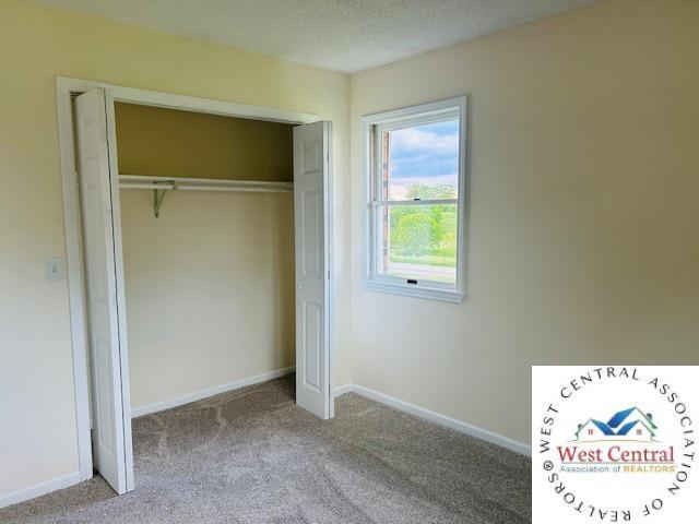 45869 E Hwy, Milan, MO 63556 - unfurnished bedroom featuring carpet, a closet, and a textured ceiling
