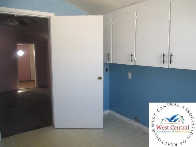 clothes washing area with a ceiling fan and light floors