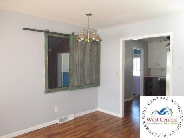 unfurnished dining area with baseboards, visible vents, a notable chandelier, and dark wood-type flooring