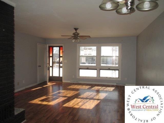 interior space with wood finished floors, ceiling fan with notable chandelier, and baseboards