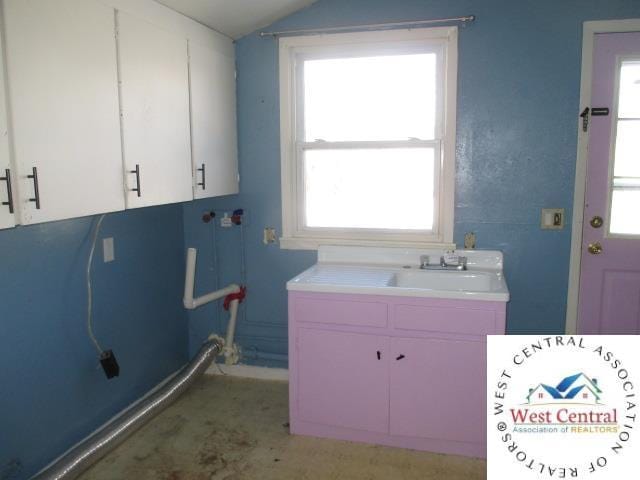 laundry area with cabinet space and a sink