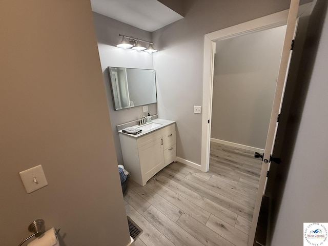 bathroom featuring wood finished floors, vanity, and baseboards