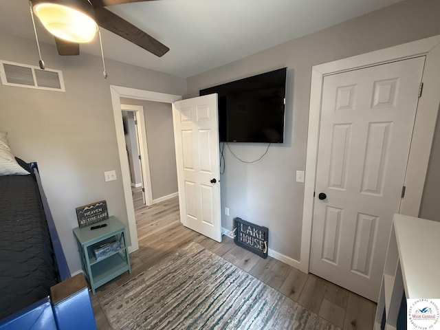 unfurnished bedroom featuring wood finished floors, baseboards, and a ceiling fan
