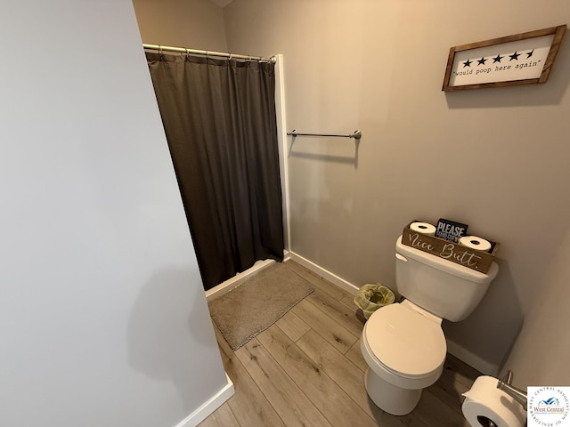 full bathroom with toilet, baseboards, wood finished floors, and curtained shower