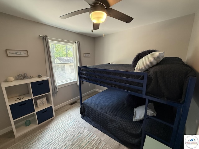 bedroom featuring light wood-type flooring, baseboards, and a ceiling fan
