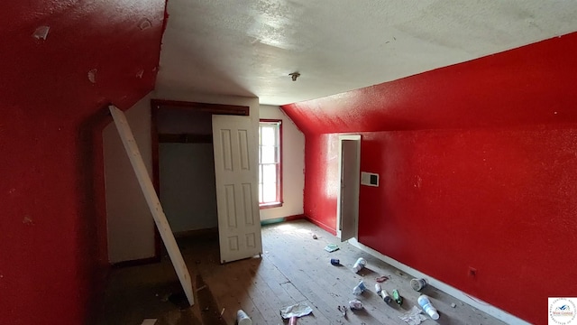 207 S Olive St, Calhoun, MO 65323 - additional living space featuring lofted ceiling, a textured ceiling, hardwood / wood-style floors, and baseboards