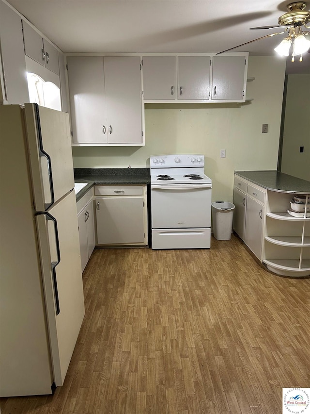 1511 Polk St, Warsaw, MO 65355 - kitchen with white appliances, dark countertops, wood finished floors, and ceiling fan