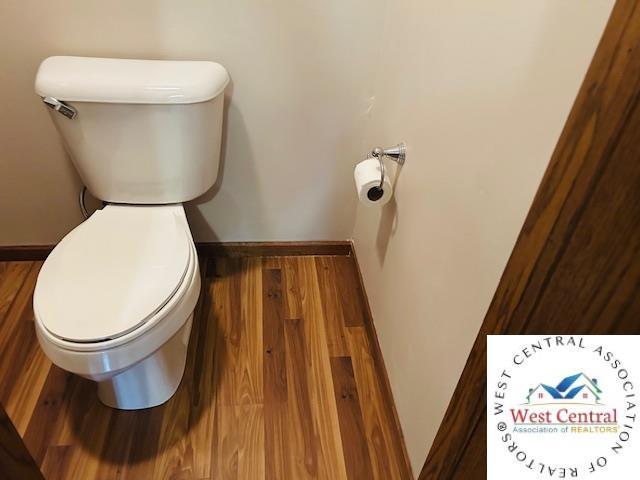 913 S Main St, Milan, MO 63556 - bathroom featuring toilet, wood finished floors, and baseboards