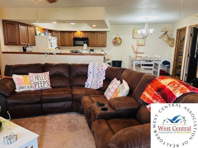 913 S Main St, Milan, MO 63556 - living area featuring light colored carpet and a notable chandelier