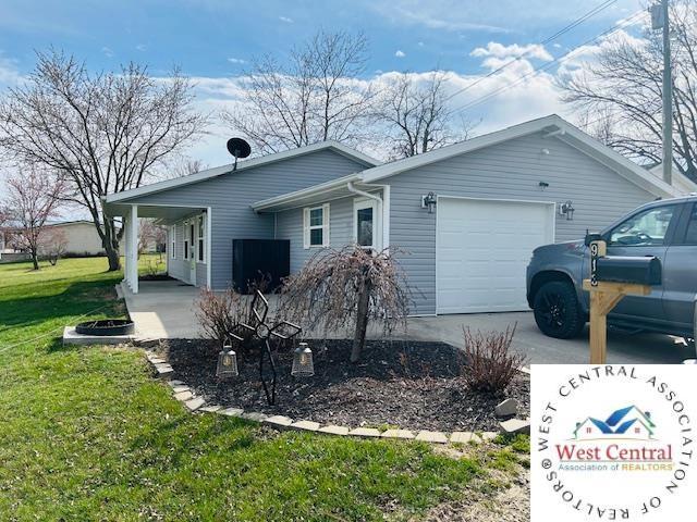 913 S Main St, Milan, MO 63556 - view of home's exterior with driveway, a yard, and an attached garage