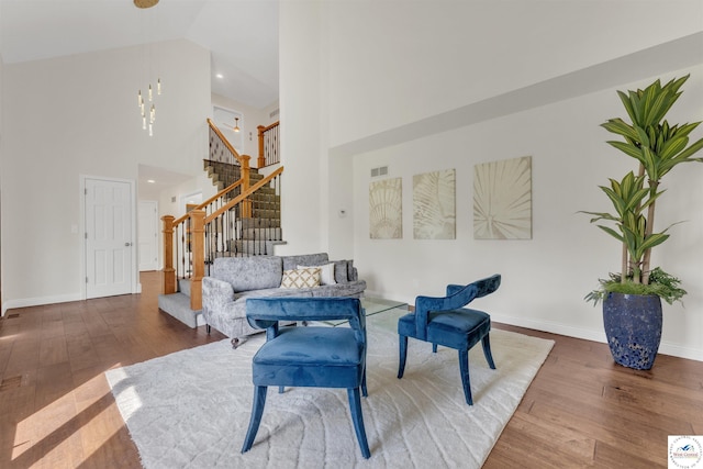 1715 Sycamore Dr, Sedalia, MO 65301 - sitting room with visible vents, baseboards, wood finished floors, a high ceiling, and stairs