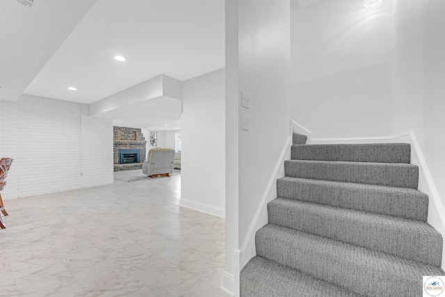 1715 Sycamore Dr, Sedalia, MO 65301 - stairway featuring marble finish floors, a fireplace, recessed lighting, and brick wall