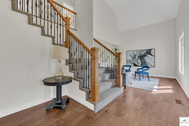 1715 Sycamore Dr, Sedalia, MO 65301 - staircase featuring wood finished floors, high vaulted ceiling, and baseboards