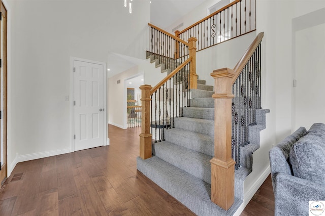 1715 Sycamore Dr, Sedalia, MO 65301 - staircase featuring a towering ceiling, visible vents, wood finished floors, and baseboards