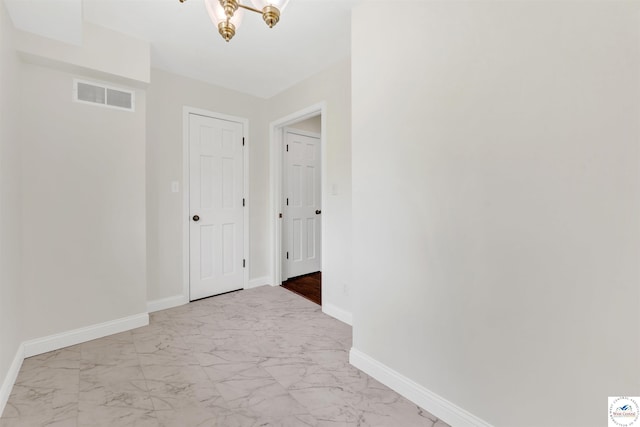 1715 Sycamore Dr, Sedalia, MO 65301 - corridor with baseboards, visible vents, a notable chandelier, and marble finish floor