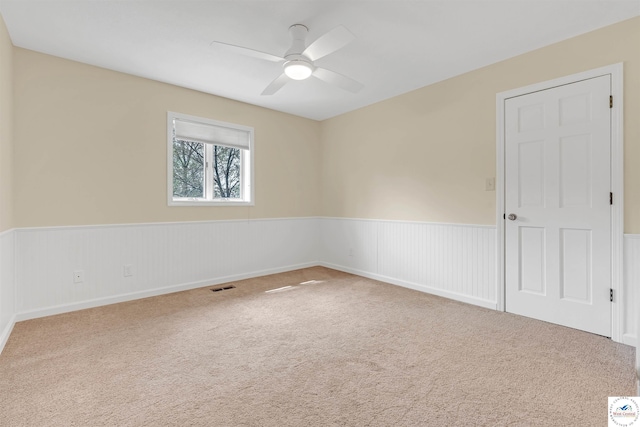 1715 Sycamore Dr, Sedalia, MO 65301 - carpeted spare room with visible vents, wainscoting, and ceiling fan