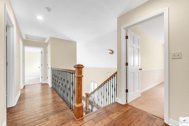 1715 Sycamore Dr, Sedalia, MO 65301 - hallway with hardwood / wood-style floors, visible vents, an upstairs landing, and baseboards