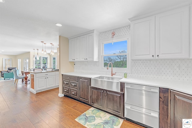 1715 Sycamore Dr, Sedalia, MO 65301 - kitchen with white cabinetry, a healthy amount of sunlight, dishwasher, and a sink