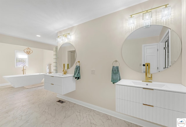 1715 Sycamore Dr, Sedalia, MO 65301 - full bathroom featuring two vanities, a soaking tub, marble finish floor, and baseboards