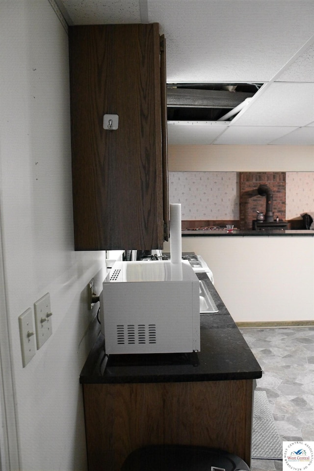 interior space with dark countertops, a paneled ceiling, and white microwave