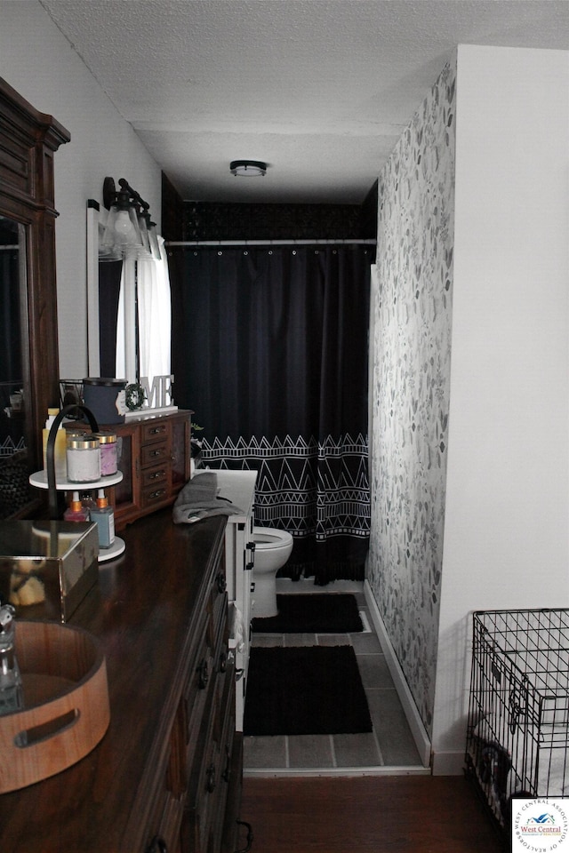full bath with vanity, curtained shower, toilet, a textured ceiling, and wood finished floors