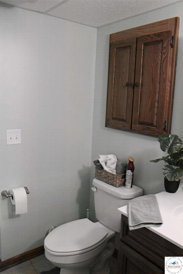 half bathroom featuring tile patterned floors, toilet, and vanity