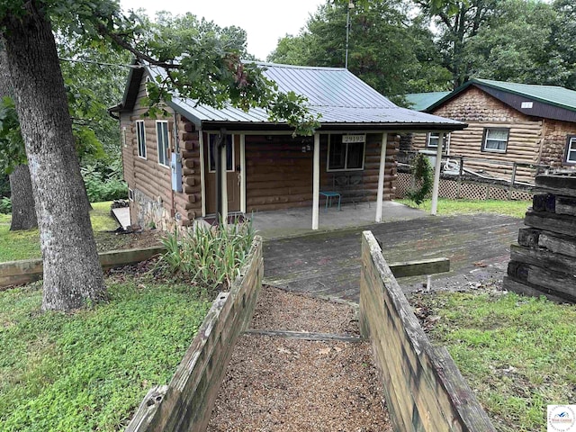 29193 Roundhouse Ave, Lincoln, MO 65338 - rear view of house featuring log exterior, a metal roof, and a wooden deck