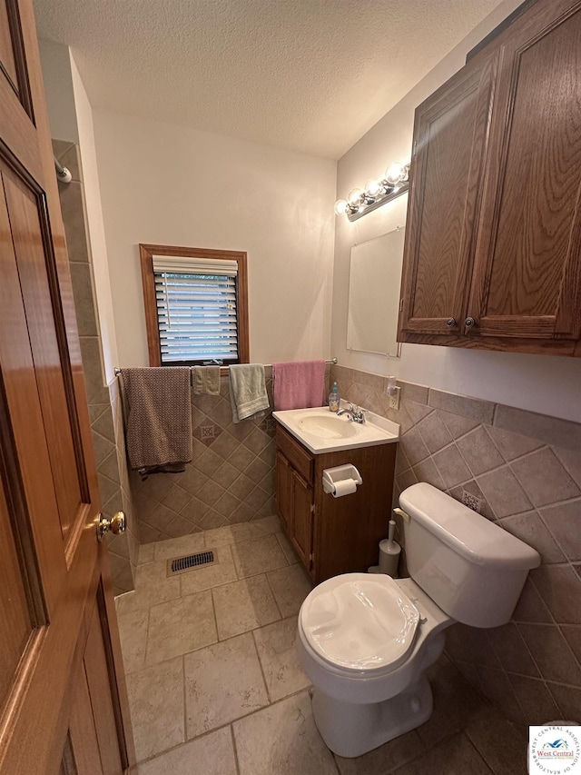 29193 Roundhouse Ave, Lincoln, MO 65338 - bathroom featuring tile walls, wainscoting, vanity, and a textured ceiling