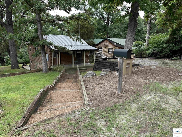 29193 Roundhouse Ave, Lincoln, MO 65338 - view of front of property with covered porch, a metal roof, a front lawn, and view of scattered trees