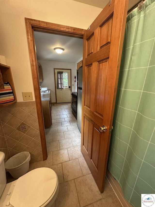 29193 Roundhouse Ave, Lincoln, MO 65338 - full bathroom featuring stone tile flooring, tile walls, and a shower with shower curtain