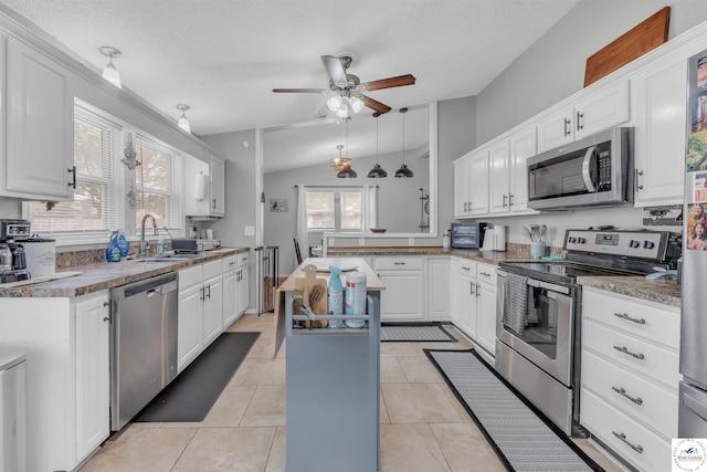 2510 Stephenson Ave, Sedalia, MO 65301 - kitchen with appliances with stainless steel finishes, a sink, a ceiling fan, white cabinetry, and vaulted ceiling