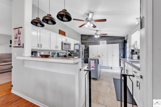 2510 Stephenson Ave, Sedalia, MO 65301 - kitchen with appliances with stainless steel finishes, ceiling fan, white cabinets, vaulted ceiling, and a peninsula