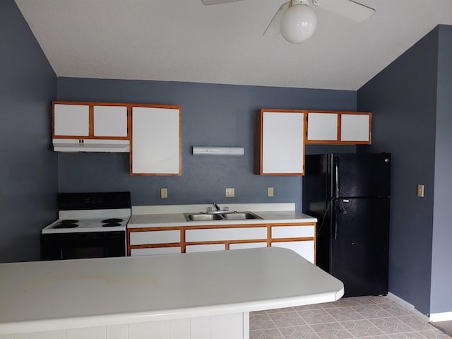 kitchen featuring a sink, under cabinet range hood, light countertops, range with electric stovetop, and freestanding refrigerator