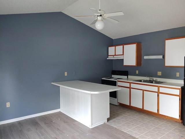 kitchen with electric stove, light countertops, a sink, light wood-type flooring, and lofted ceiling