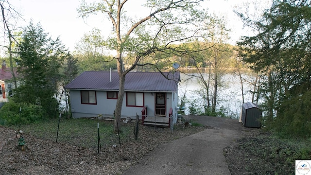 31560 Branch Ave, Warsaw, MO 65355 - view of front facade with a water view, metal roof, an outdoor structure, a shed, and aphalt driveway