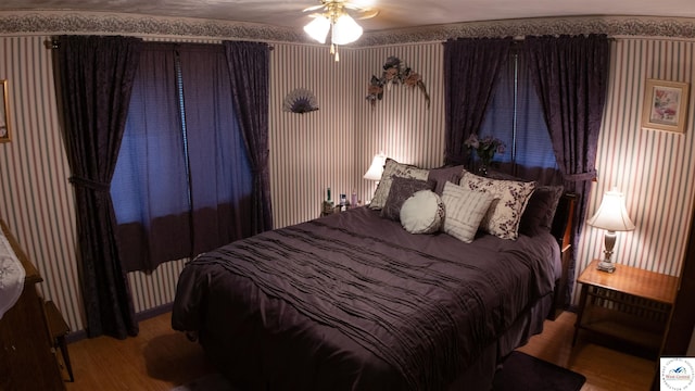 31560 Branch Ave, Warsaw, MO 65355 - bedroom featuring radiator heating unit, wallpapered walls, wood finished floors, and a ceiling fan