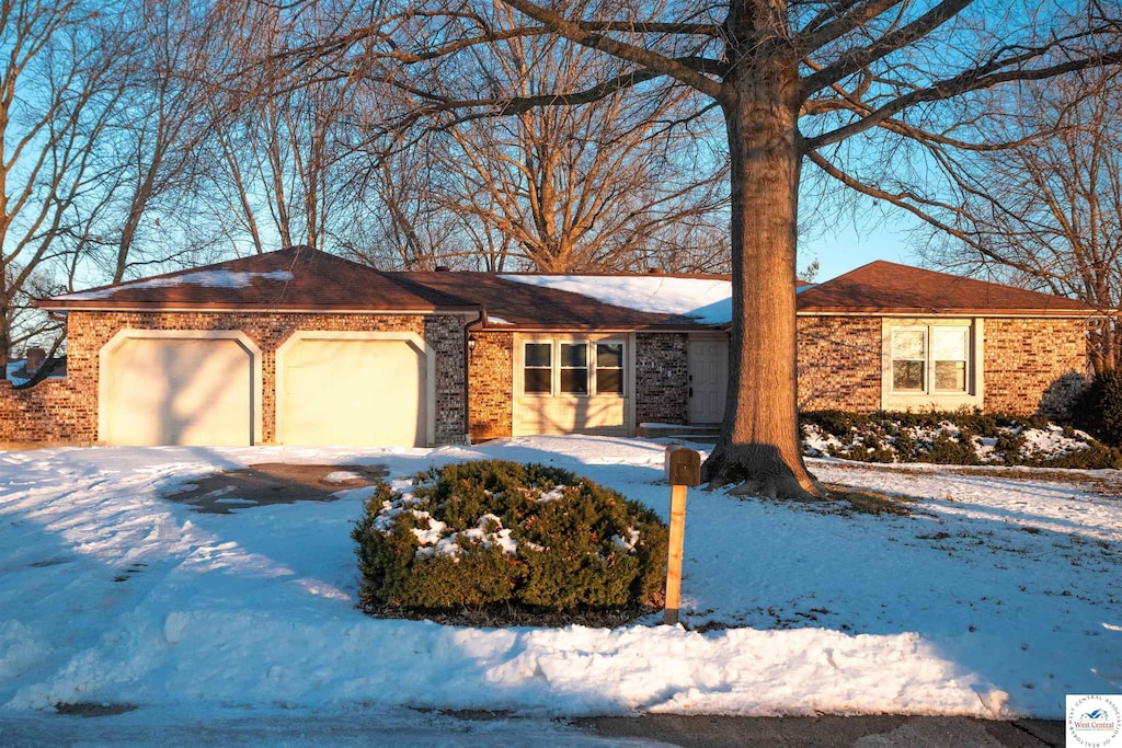 single story home featuring brick siding and an attached garage