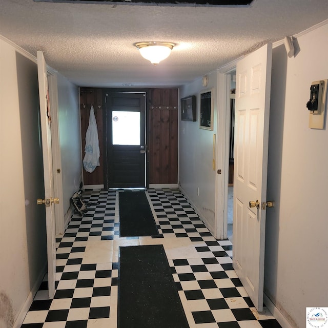 foyer entrance featuring tile patterned floors, baseboards, and a textured ceiling