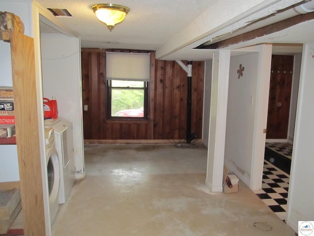 laundry area featuring wood walls and washing machine and clothes dryer