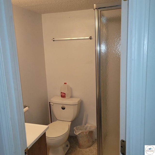 bathroom with a shower stall, vanity, toilet, speckle patterned floor, and a textured ceiling