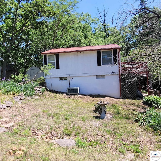 view of home's exterior featuring metal roof and central AC