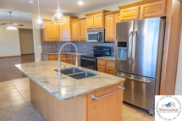 kitchen with a sink, a center island with sink, tasteful backsplash, a ceiling fan, and appliances with stainless steel finishes