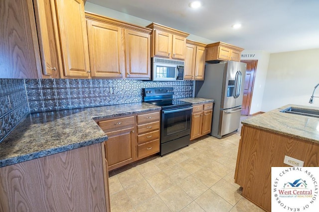 kitchen with dark stone countertops, tasteful backsplash, appliances with stainless steel finishes, a sink, and visible vents