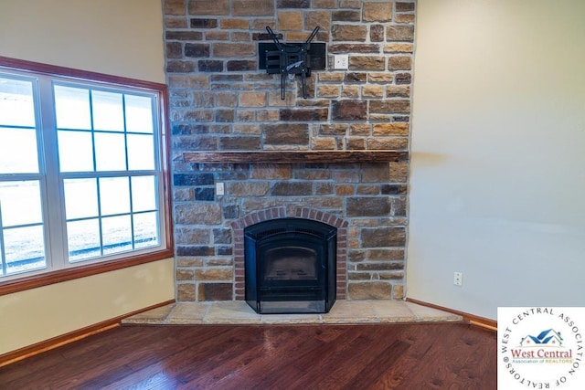 room details featuring a fireplace, wood finished floors, and baseboards