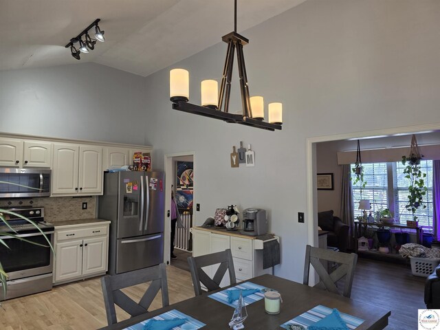 1010 NW Scenic Dr, Grain Valley, MO 64029 - dining area with high vaulted ceiling and light wood-type flooring
