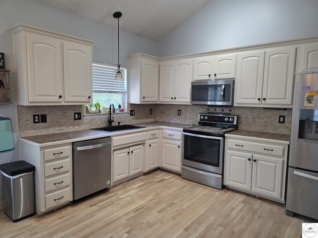 1010 NW Scenic Dr, Grain Valley, MO 64029 - kitchen featuring stainless steel appliances, lofted ceiling, decorative light fixtures, backsplash, and light wood-type flooring
