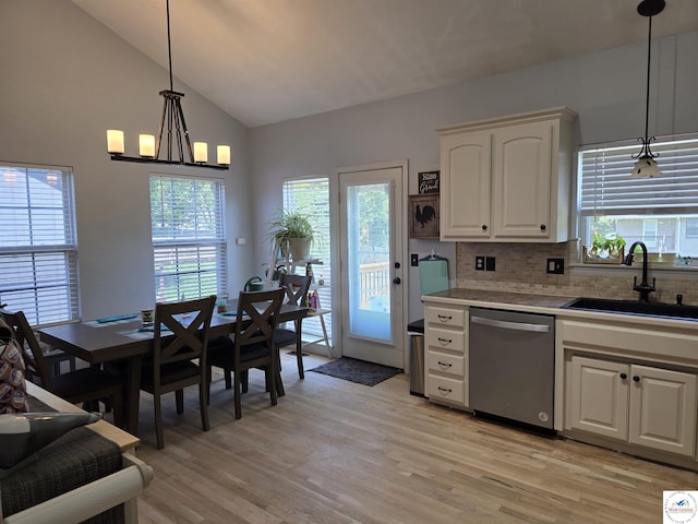 1010 NW Scenic Dr, Grain Valley, MO 64029 - kitchen with stainless steel dishwasher, tasteful backsplash, light wood-style floors, decorative light fixtures, and high vaulted ceiling